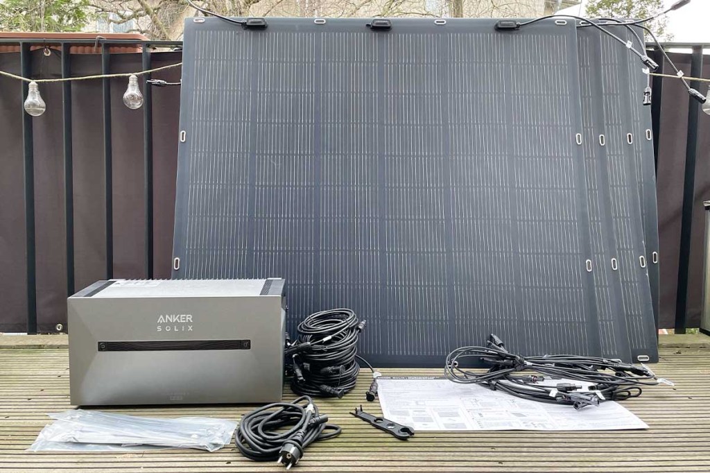Alle Einzelteile des Anker Solix Solarbank 2 Pro Systems auf einem Balkon.