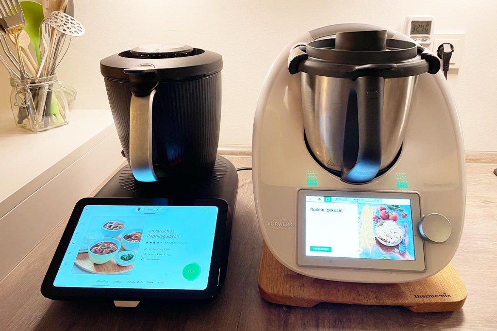 Die Thermomixe TM6 und TM7 nebeneinander in Küchenumgebung.