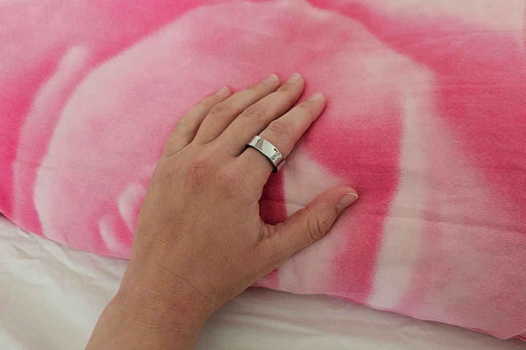 Smart Ring an Hand auf einem Kissen