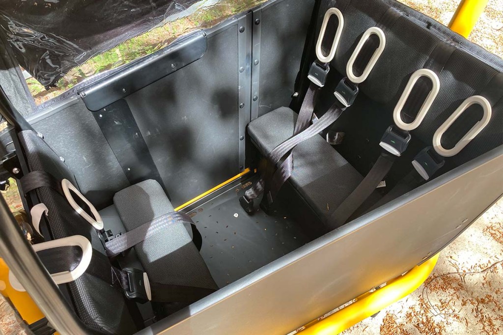 Blick in die Transportbox eines Cargo-E-Bikes, man sieht drei Kindersitze