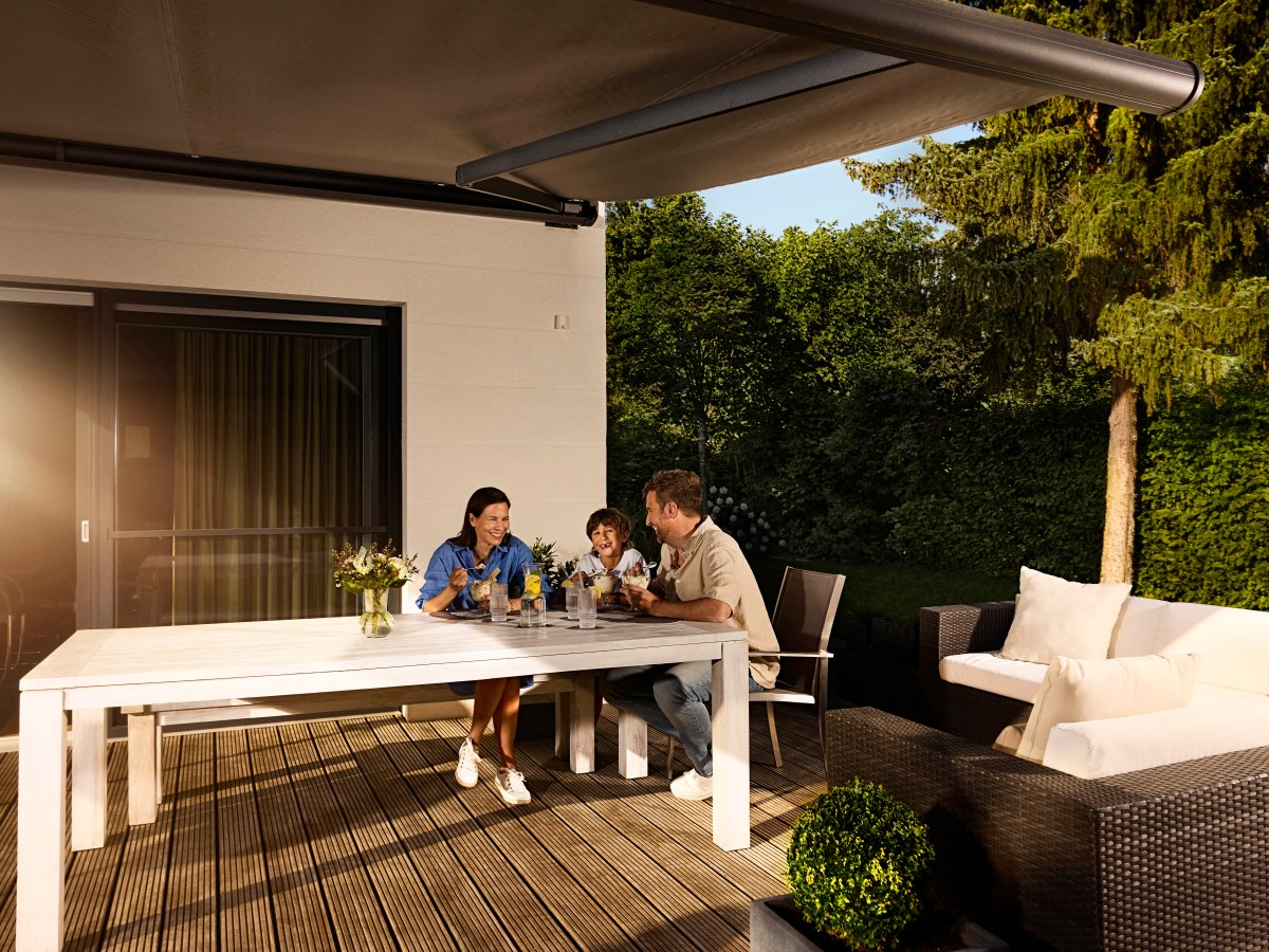 Eine Familie sitzt am Gartentisch.