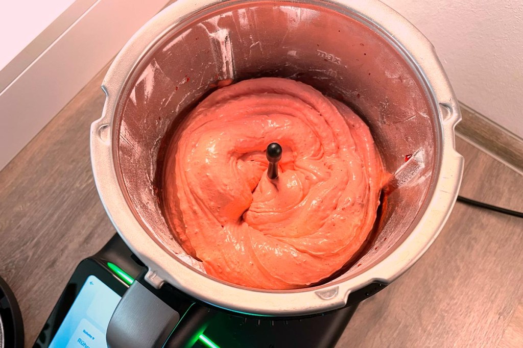 Der Thermomix TM7 Mixtopf mit rosa Masse darin und Spitze des Butterfly-Aufsatzes.