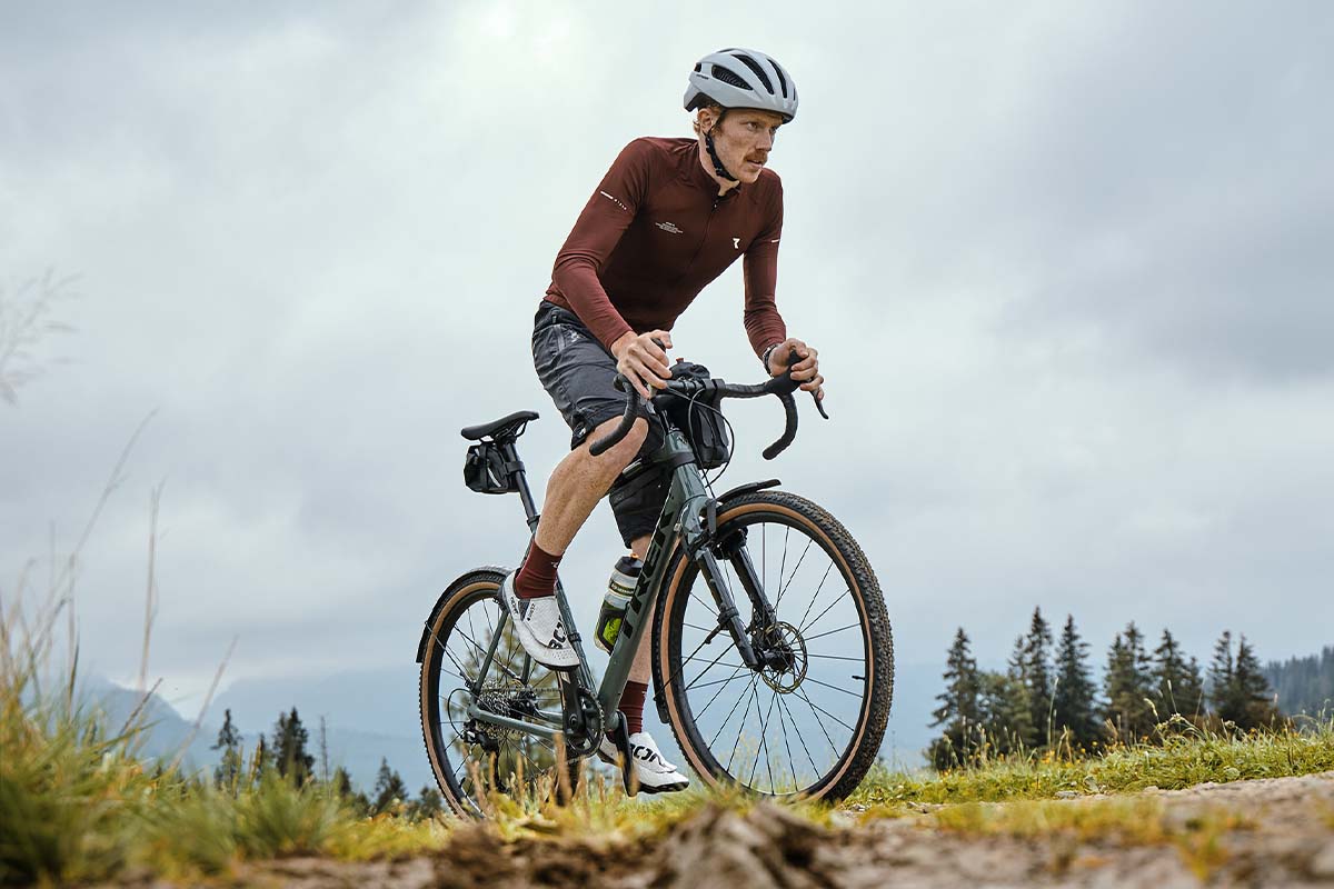 Mann fährt mit seinem Gravelbike durch die Natur